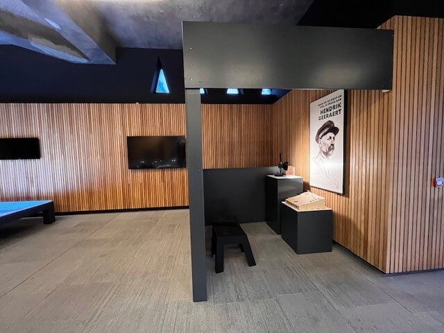A wider view of the Hendrik Geeraert corner in the Westfront exhibition, with the poster, the console and a stool