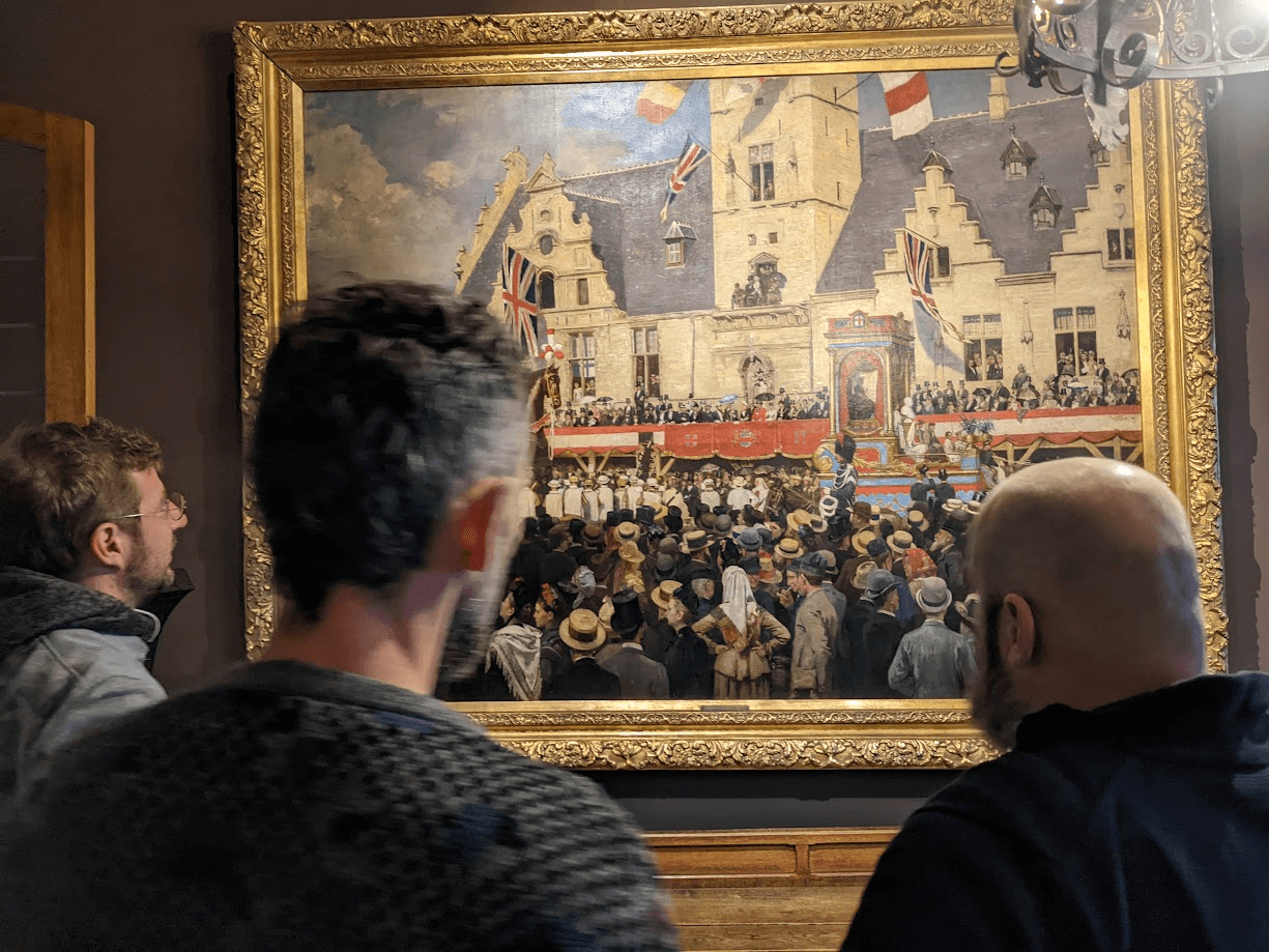 Visitors seen from behind looking up at the talking Ros Beiaard painting in its gold frame