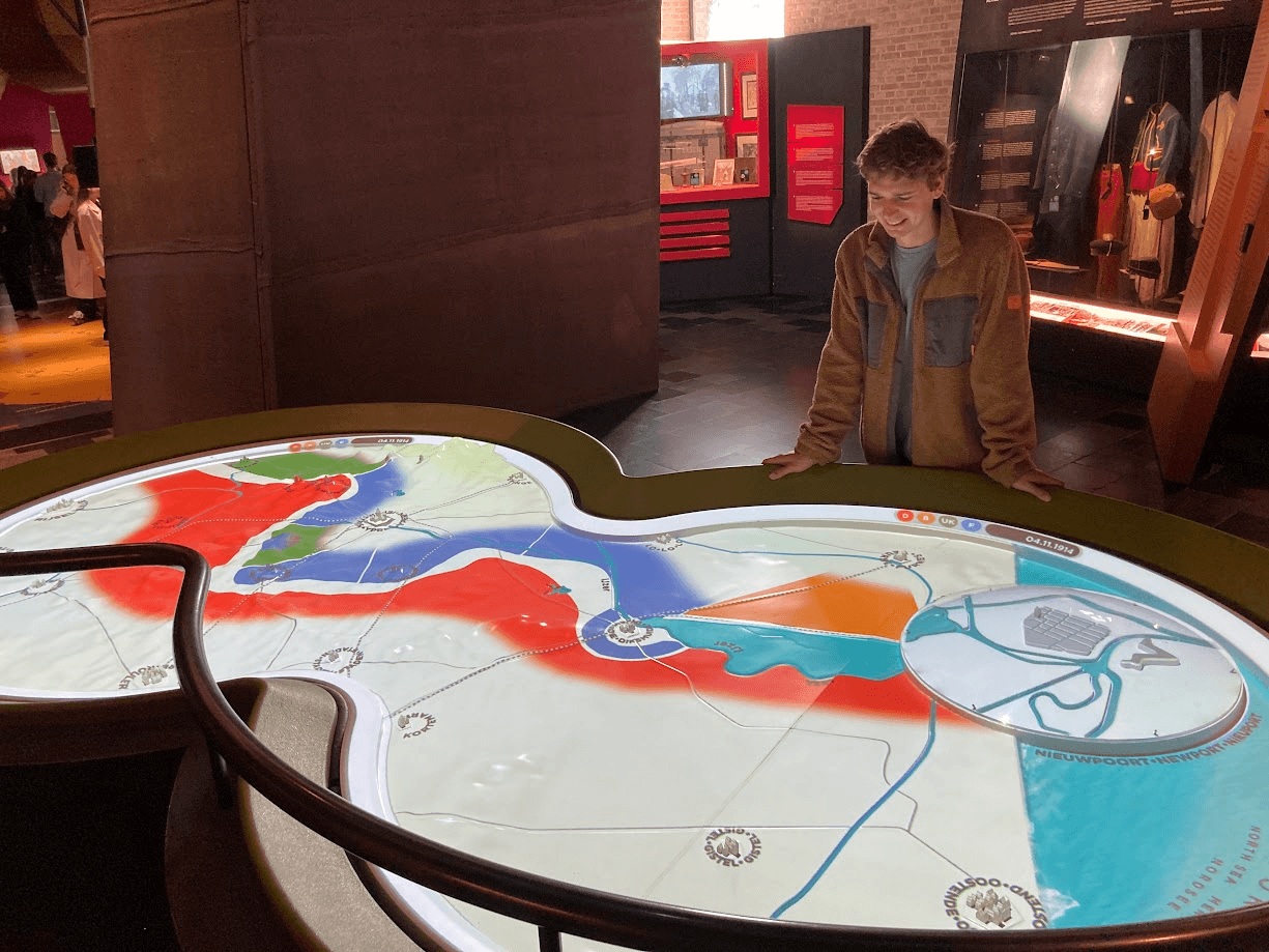 A visitor studying a wall sized military map inside the In Flanders Fields Museum